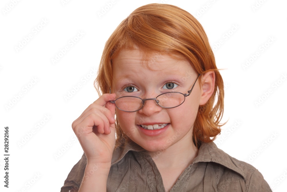 Rothaariges Mädchen schaut skeptisch über ihre Brille Rothaariges Mädchen schaut skeptisch über ihre Brille