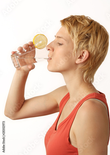 Frau trinkt aus einem Wasserglas