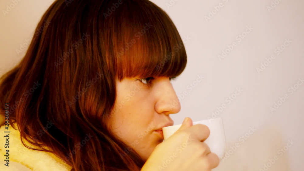 Attractive woman in bathrobe drinking cofee in bed, dolly shot Attractive woman in bathrobe drinking cofee in bed, dolly shot