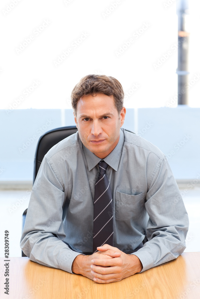 Confident manager posing alone at a table Confident manager posing alone at a table