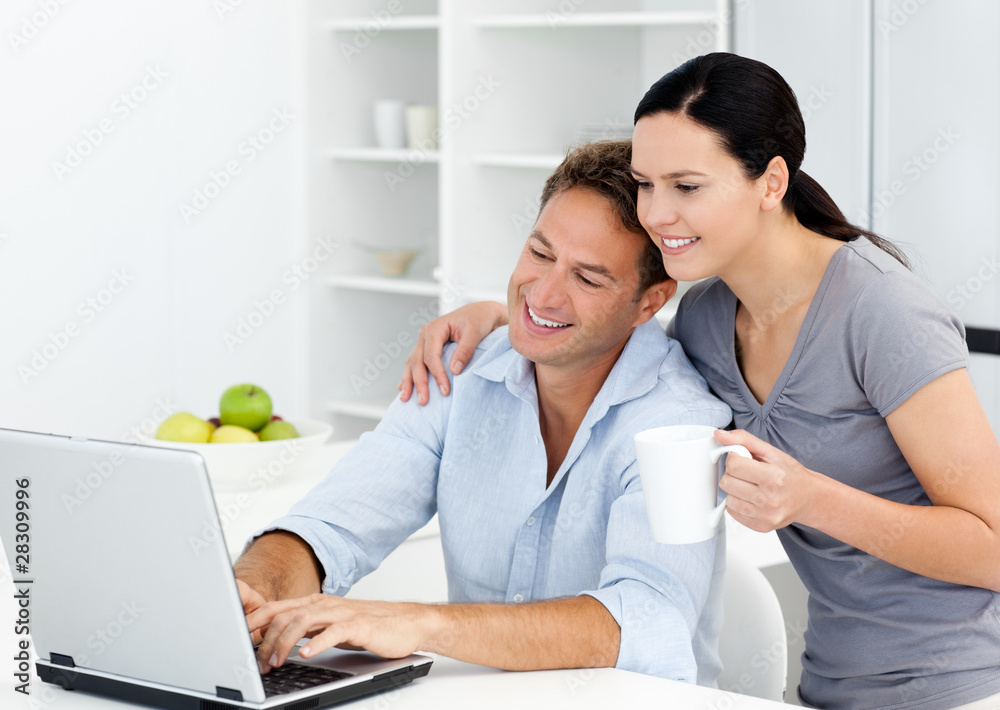 Affectionate woman looking at her boyfriend working on the lapto Affectionate woman looking at her boyfriend working on the lapto