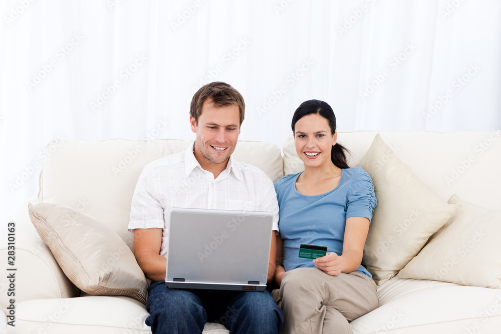 Happy couple buying online with laptop and credit card Happy couple buying online with laptop and credit card