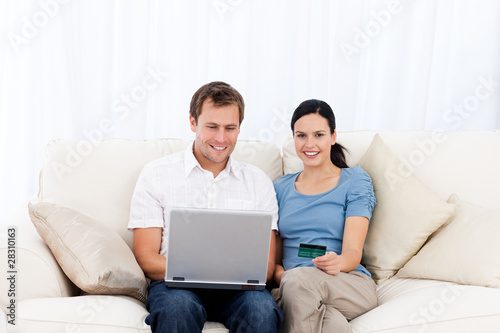 Happy couple buying online with laptop and credit card