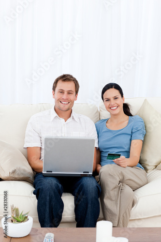 Portrait of a happy couple buying online with their credit card