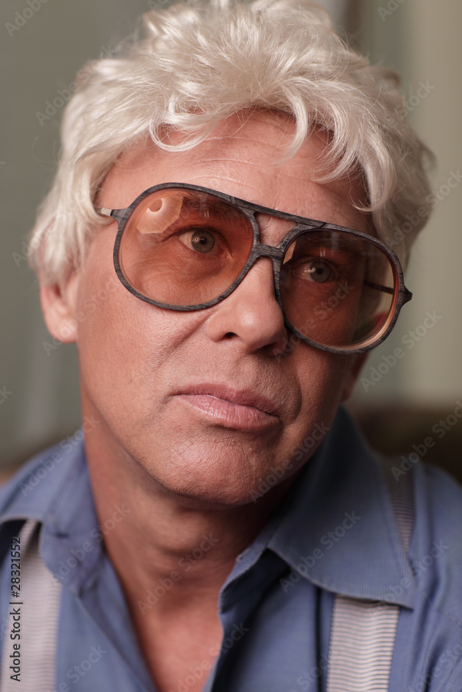 Headshot of a man wearing oversized glasses and looking away Headshot of a man wearing oversized glasses and looking away