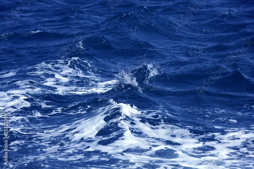 Blue wawy water with white foam in storme sea ocean surface