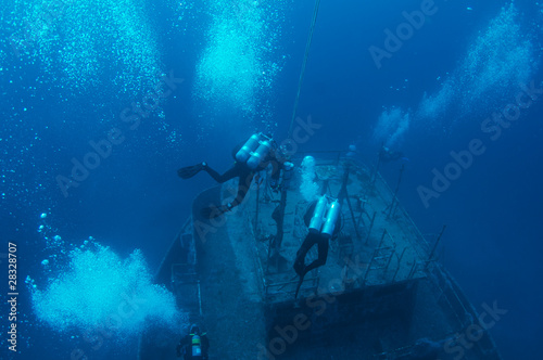 Scuba divers descending on a shipwreck. © pipehorse