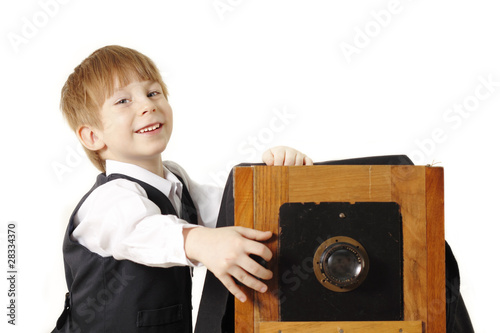 cheerful boy retro photographer with vintage camera in studio photo