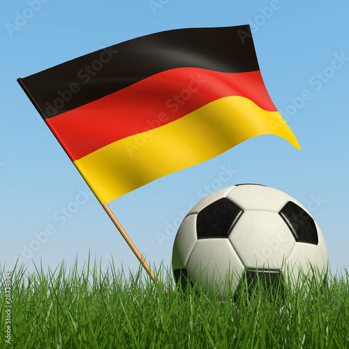 Soccer ball in the grass and flag of Germany
