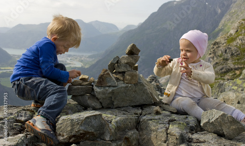 Foto Children (1 and 3 years old) building a cairn on a mountaintop