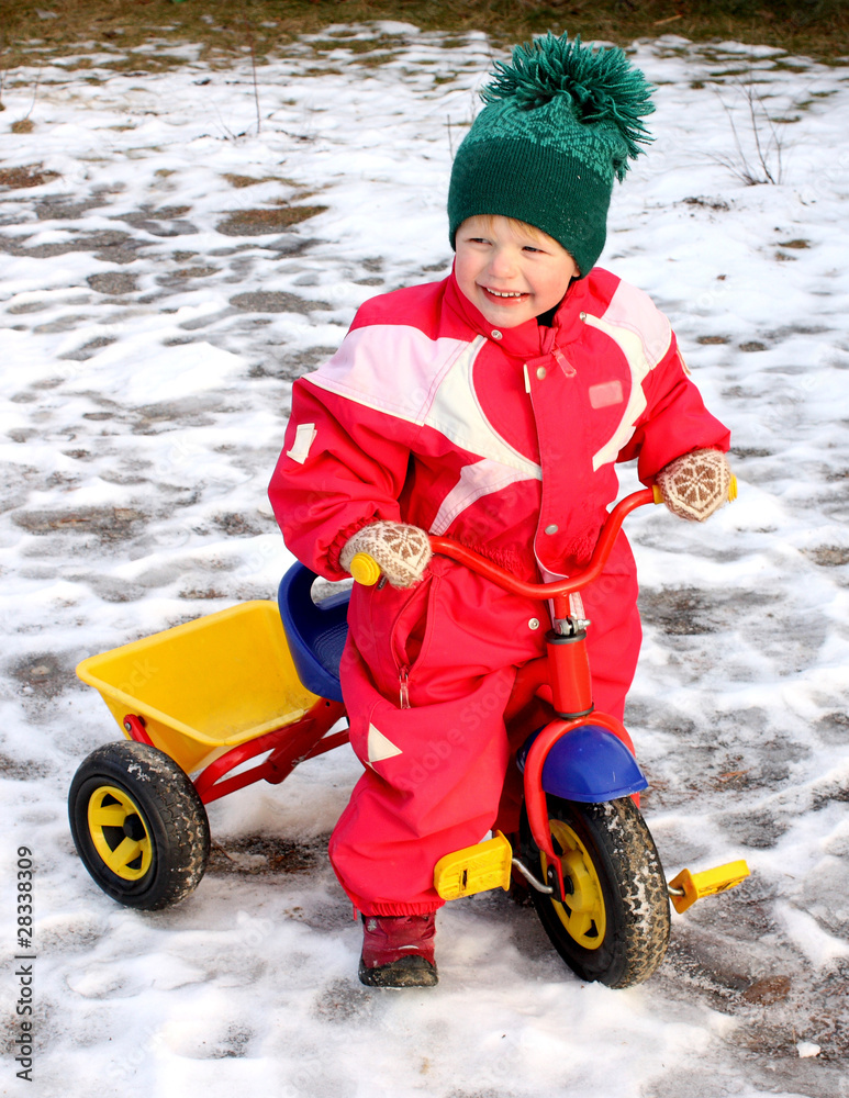 Optimistic child getting her tricycle ready for spring, Optimistic child getting her tricycle ready for spring,