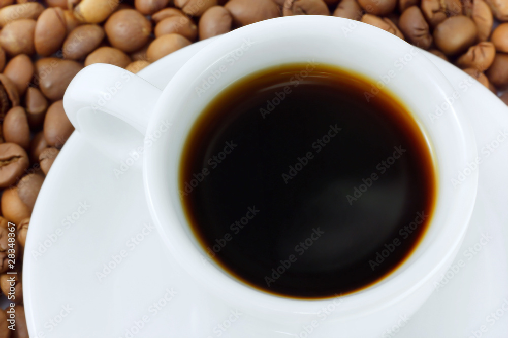 Cup with beverage and coffee beans as background