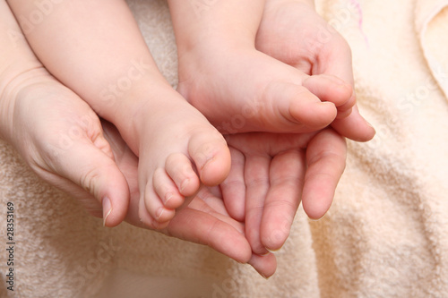 children's feet in the hands of the mother