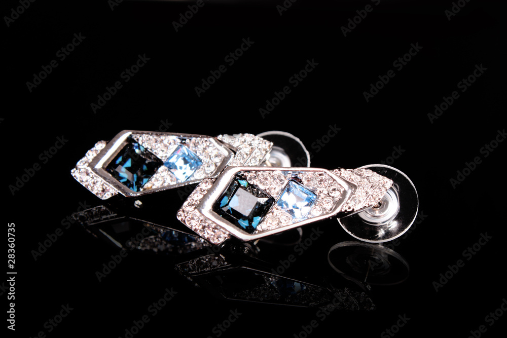 Beautiful earrings with gems on black background Beautiful earrings with gems on black background