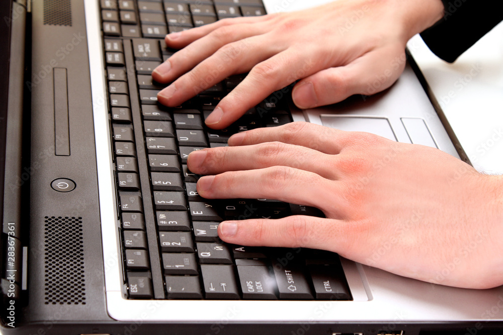 Male fingers typing a document on the black laptop Male fingers typing a document on the black laptop