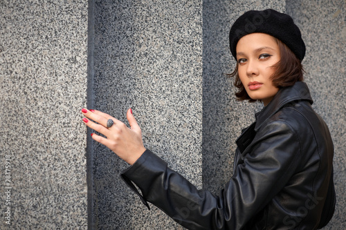 Beautiful young woman near stone wall
