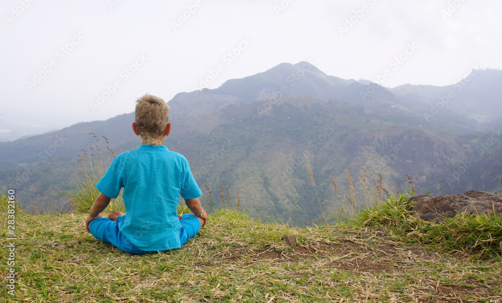 Photo of a boy meditating in mountain