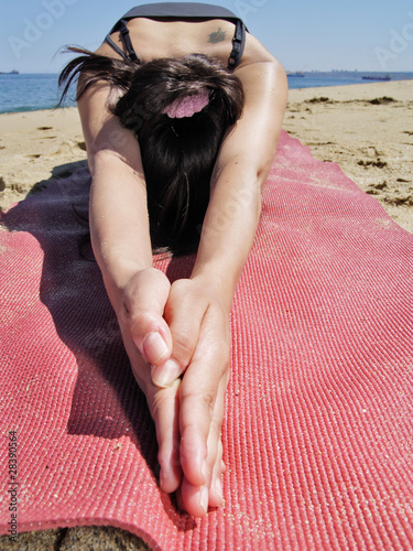 Bikram yoga ardha kurmasana pose at beach photo