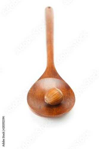 hazelnuts on a wooden spoon isolated on white