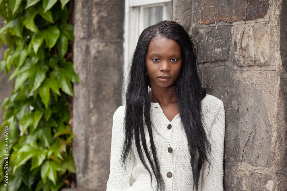 African American standing in front of stone wall African American standing in front of stone wall