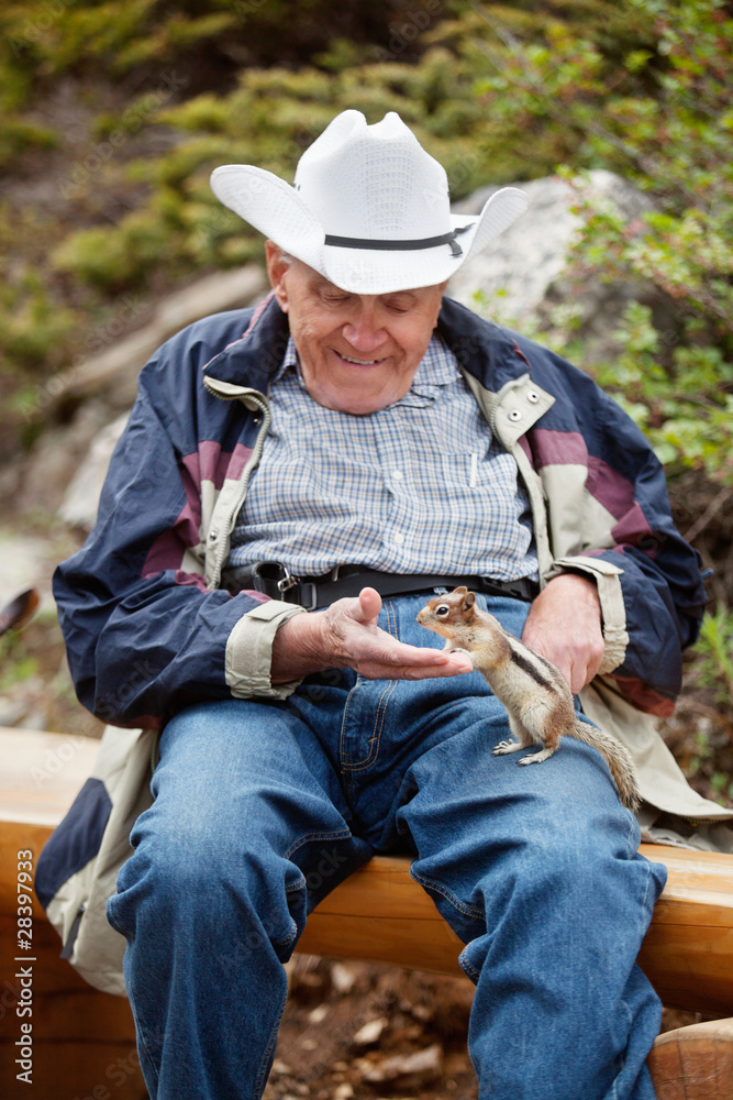 Elderly man playing with squirrel Elderly man playing with squirrel