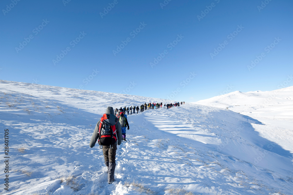 Hikers in winter in mountains