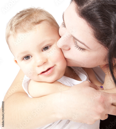 Happy young mother kissing a baby