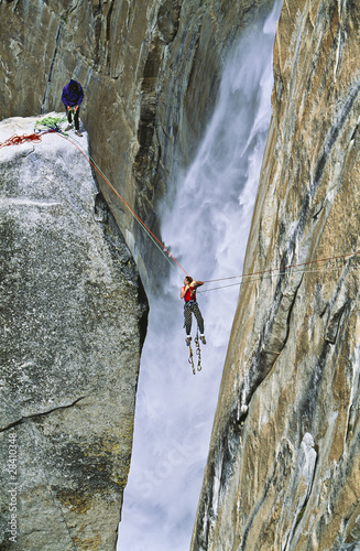 Rock climbing team reaching the summit.