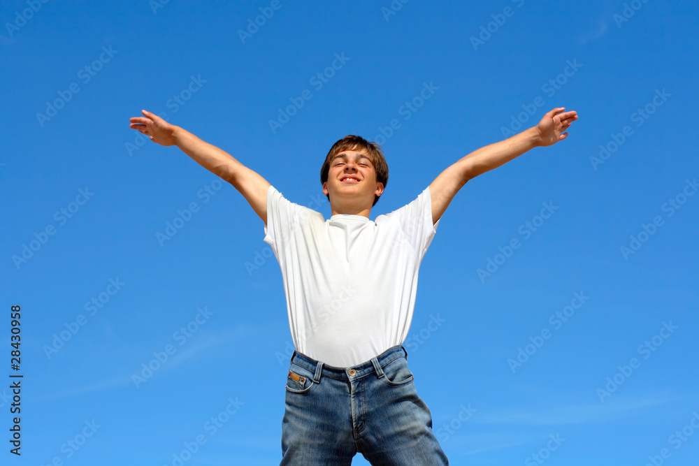 happy teenager jumping on blue sky background happy teenager jumping on blue sky background