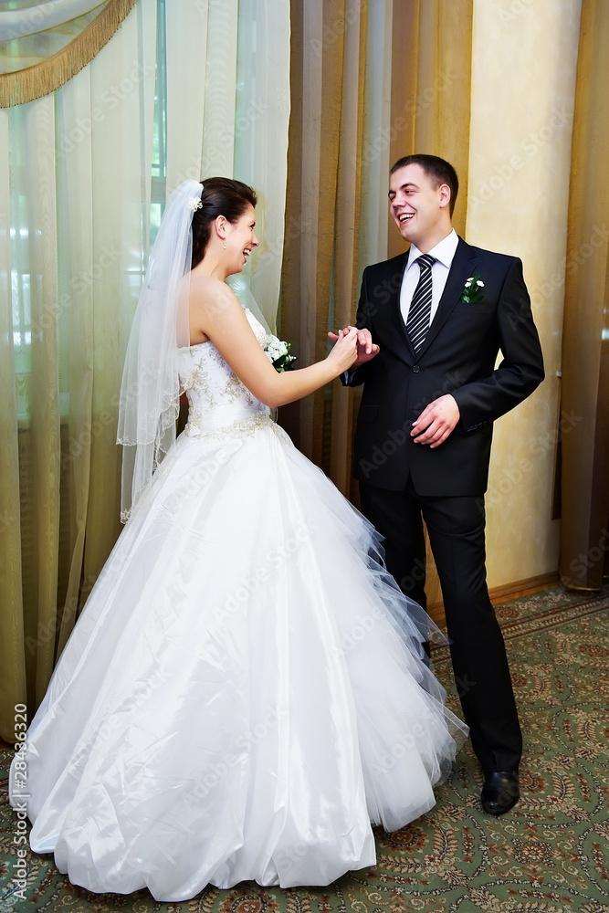 Funny bride wears the ring on his hand a happy groom