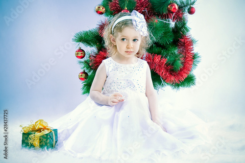 cute girl wearing snowflake costume under xmas tree
