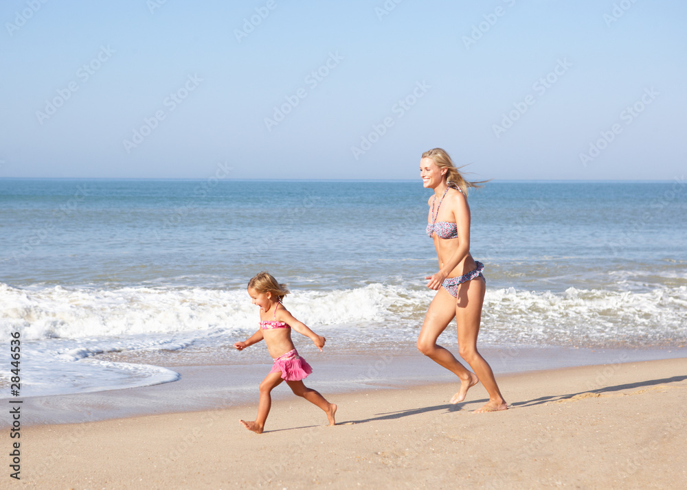 Fototapeta premium Mother chasing young girl on beach