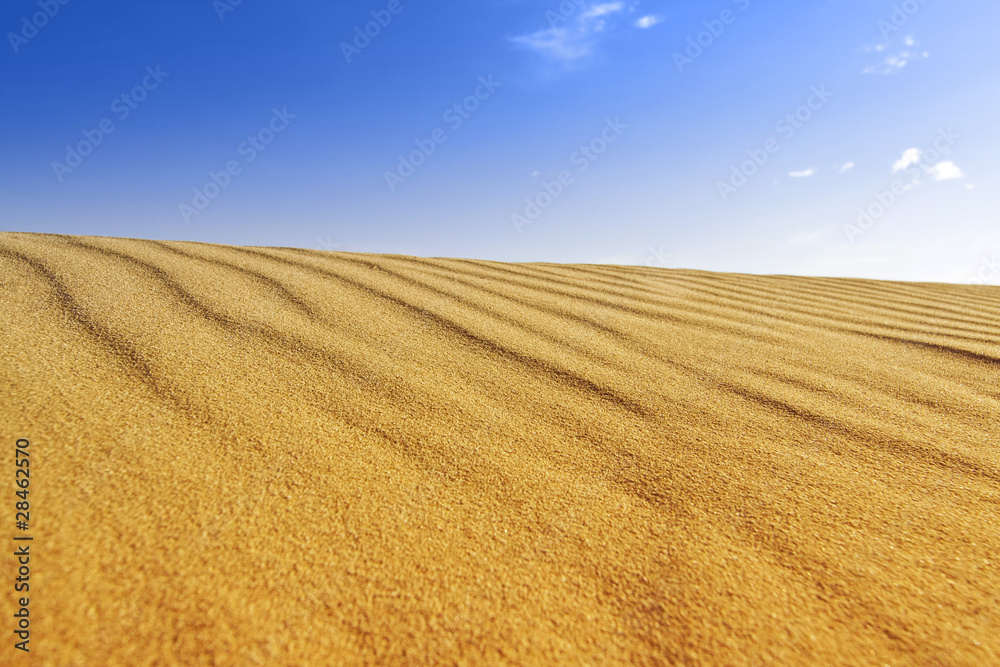 Background of golden sand dune and blue sky