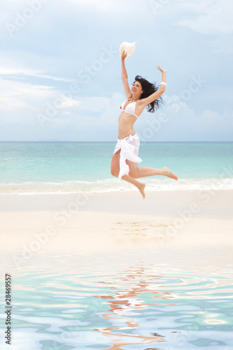 happy young woman jumping in the beach