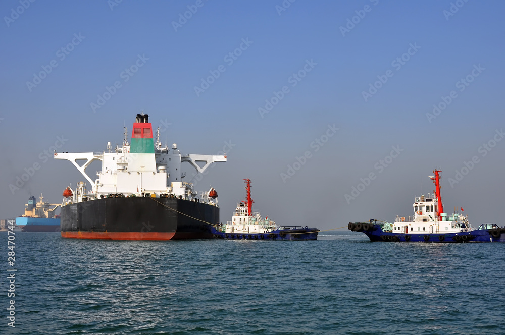 Oil tanker and tugboats