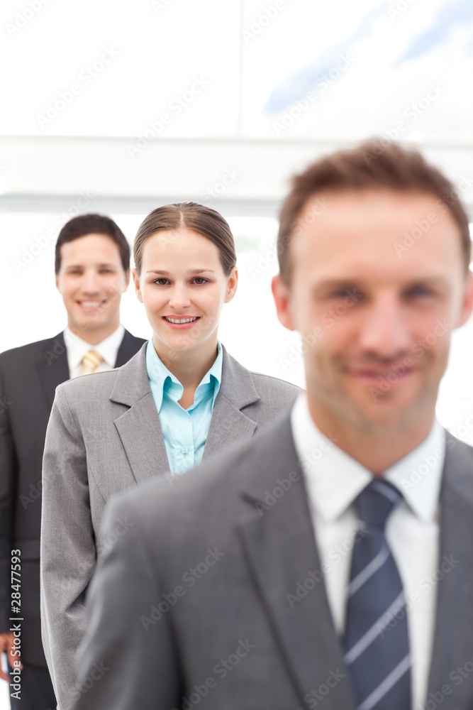 Young businesswoman posing with two businessmen in a row Young businesswoman posing with two businessmen in a row
