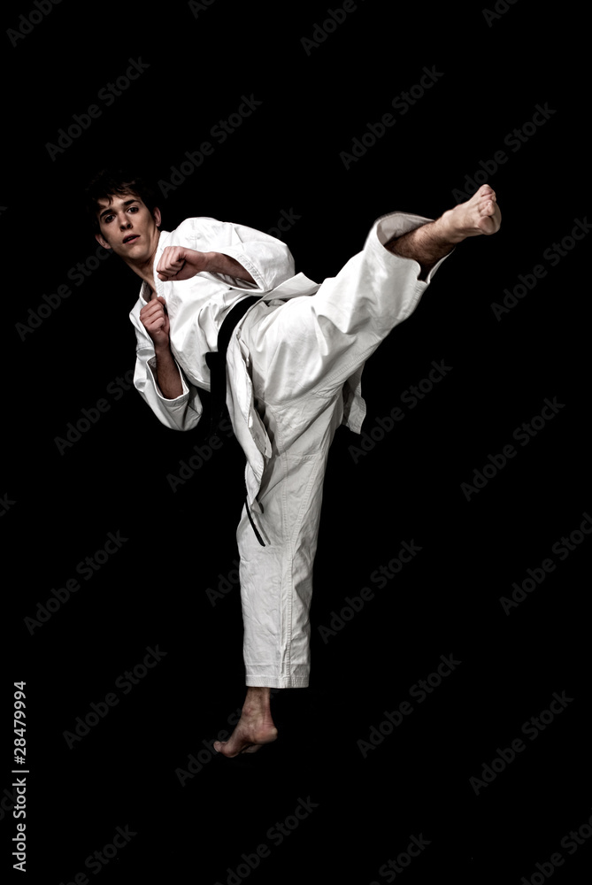 Karate male fighter young high contrast on black background.