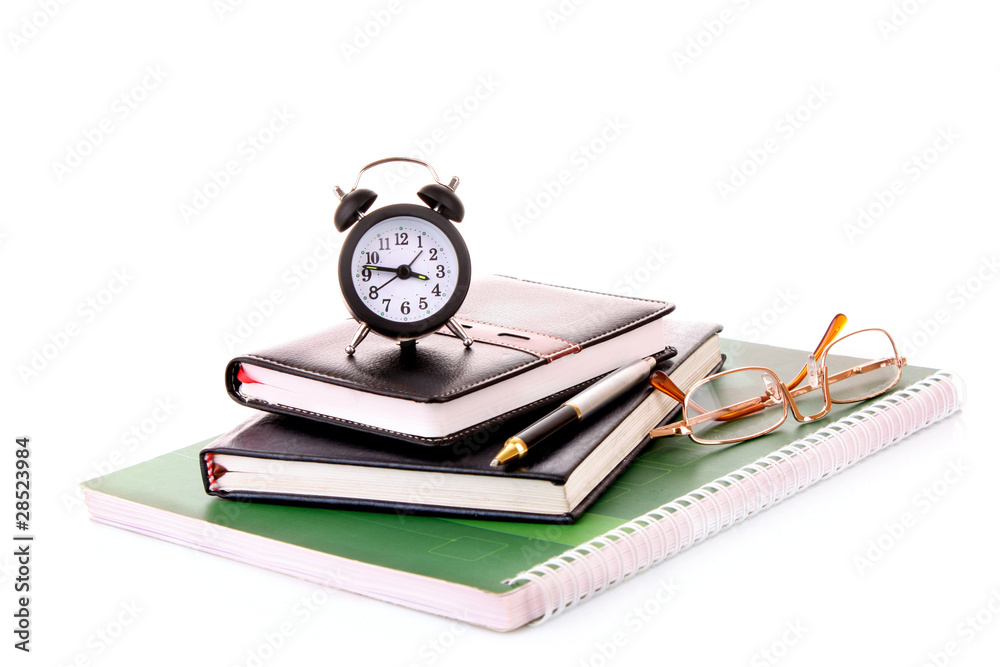 Glasses on notebooks and clock isolated on white Glasses on notebooks and clock isolated on white