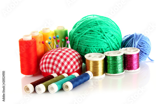 Coloured bobbins of threads, woolen balls and cushion for pins i