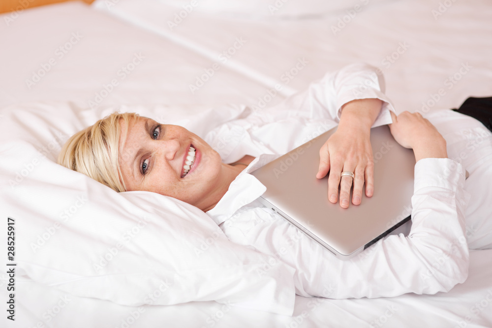 frau mit laptop auf dem bett frau mit laptop auf dem bett