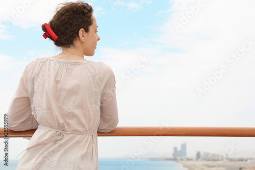 woman in Qaboos Port. Shore and building in out of focus.