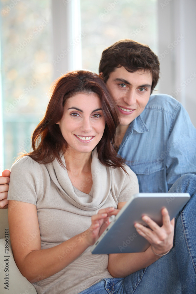 Young couple using electronic tablet at home Young couple using electronic tablet at home