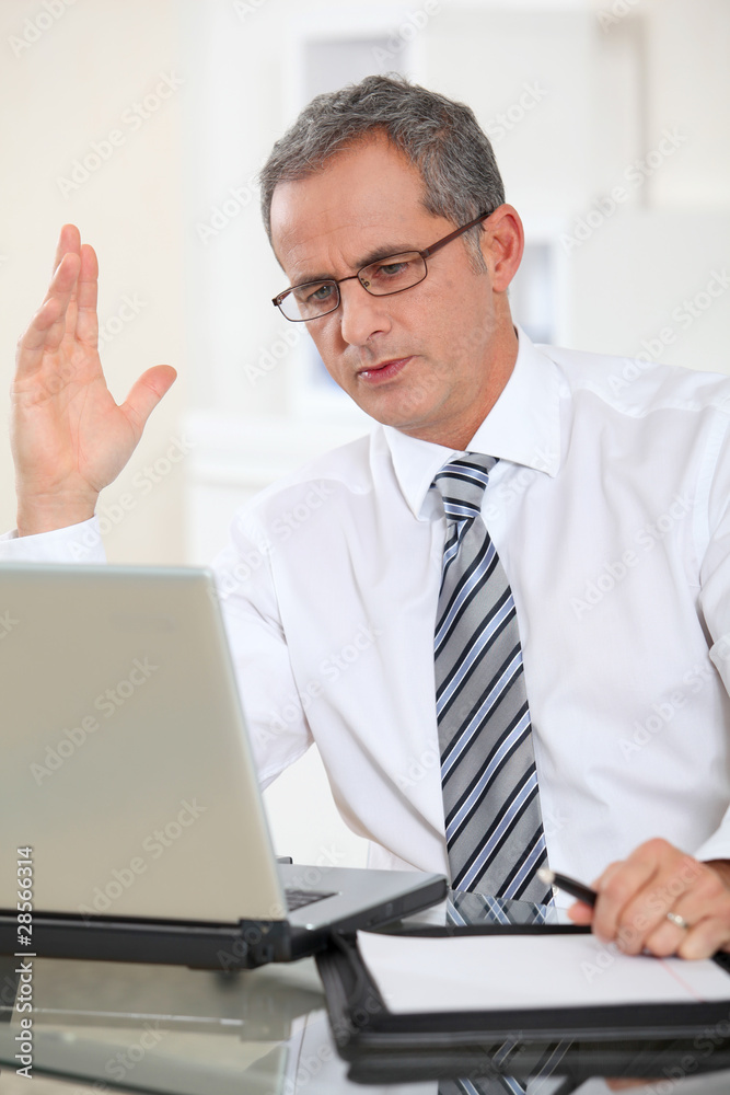 Portrait of businessman working on laptop computer