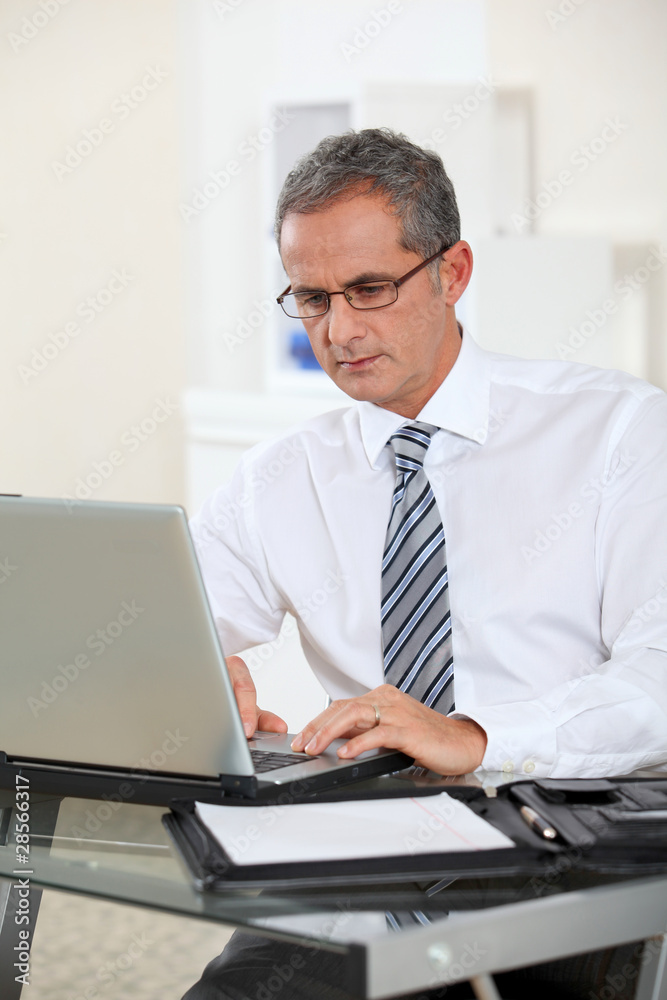 Portrait of businessman working on laptop computer Portrait of businessman working on laptop computer