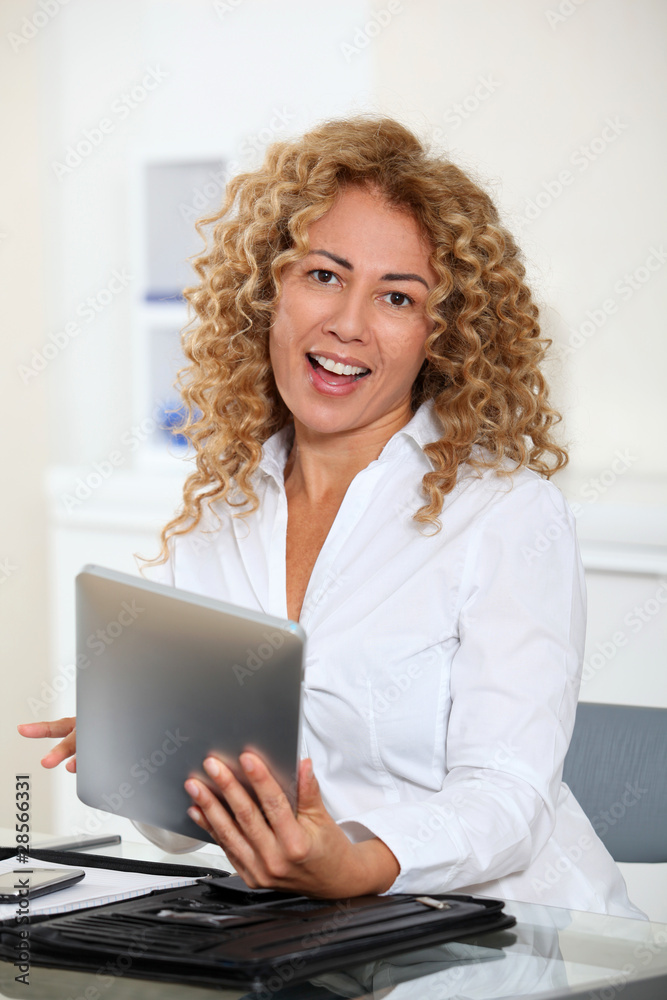 Businesswoman in office using electronic tab