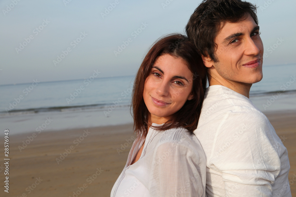 Young happy couple standing on a beach Young happy couple standing on a beach