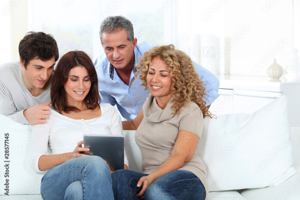 Group of friends sitting in sofa with electronic tab Group of friends sitting in sofa with electronic tab