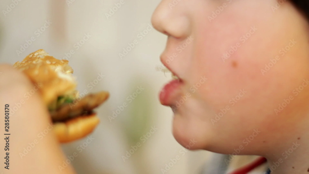 Closeup of children mouth eating hamburger Closeup of children mouth eating hamburger