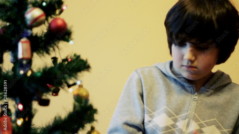 Young boy preparing the Christmas tree, dolly shot Young boy preparing the Christmas tree, dolly shot