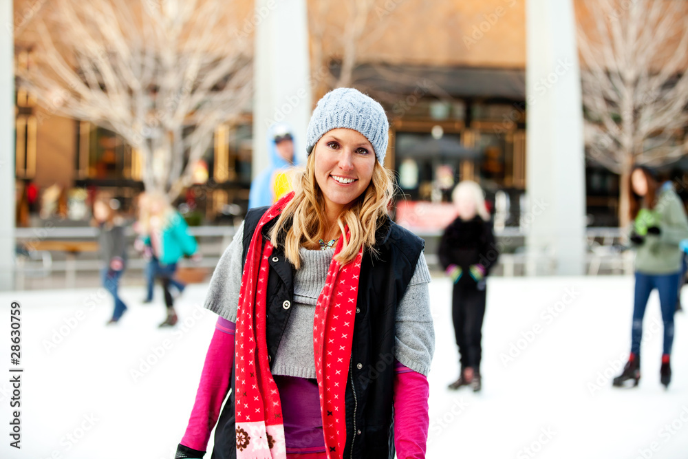 A woman smiling at an outdoor ice rink